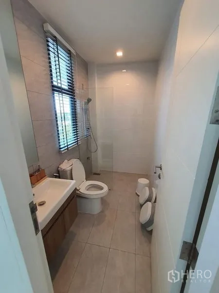 联排别墅 出售在Lat Phrao, Bangkok - 家庭浴室，淋浴、洗手台与儿童友好双座便器。