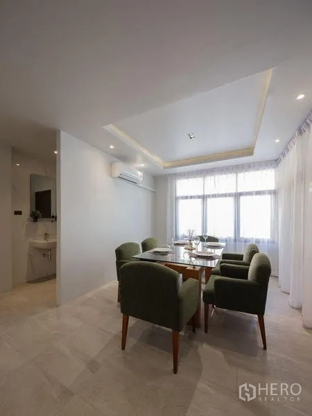 Detached House for sale in Chatuchak, Bangkok - Bright dining corner with table for four, large windows, sheer curtains and tray ceiling.