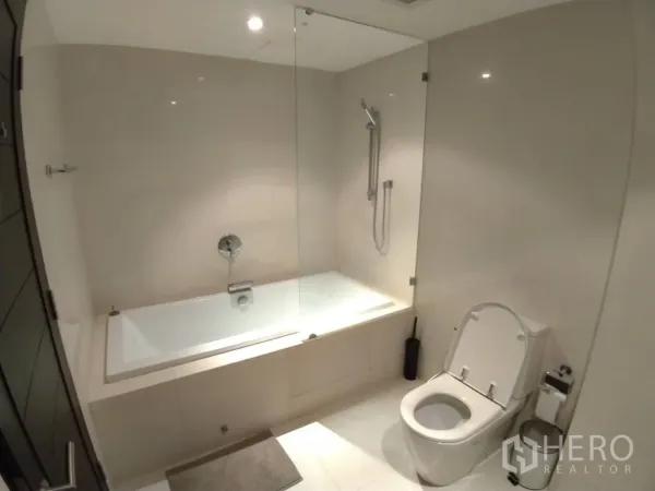 คอนโด ให้เช่าในWatthana, Bangkok - ห้องน้ำสไตล์มินิมอลพร้อมอ่างอาบน้ำบิวท์อิน ฉากกั้นกระจก และโถสุขภัณฑ์ ในคอนโดย่านทองหล่อ