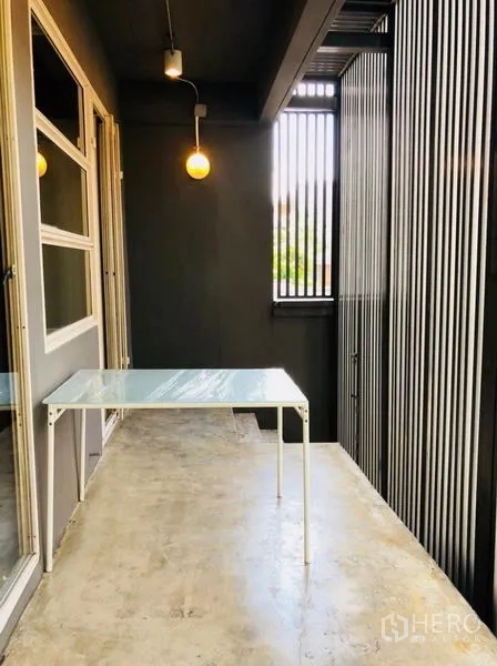 Home Office for rent in Huai Khwang, Bangkok - Shaded balcony workspace with hanging lights and louver screen.