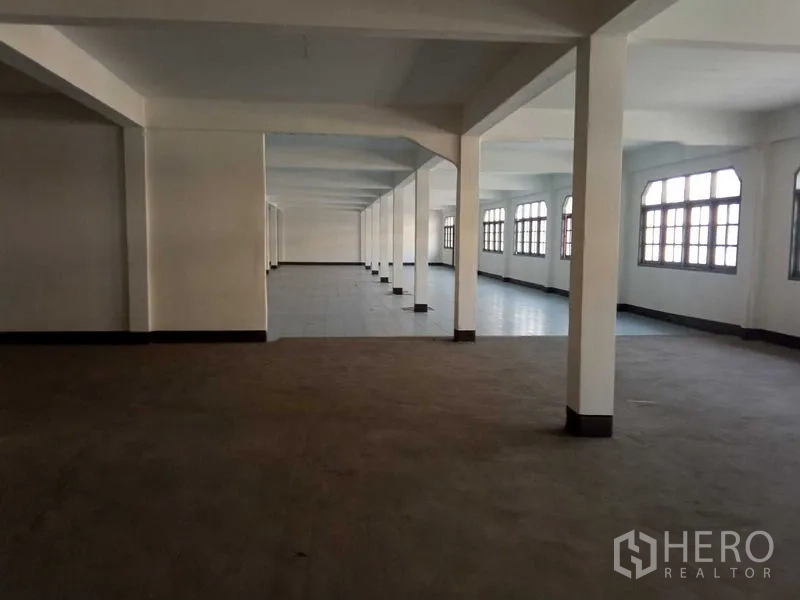 Warehouse for rent in Nong Khaem, Bangkok - Spacious warehouse floor with rows of white columns and large windows.