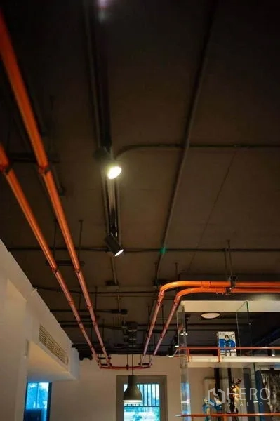 办公空间 出租在Khlong Toei, Bangkok - 特写：外露天花与橙色管线、轨道灯，工业风格。