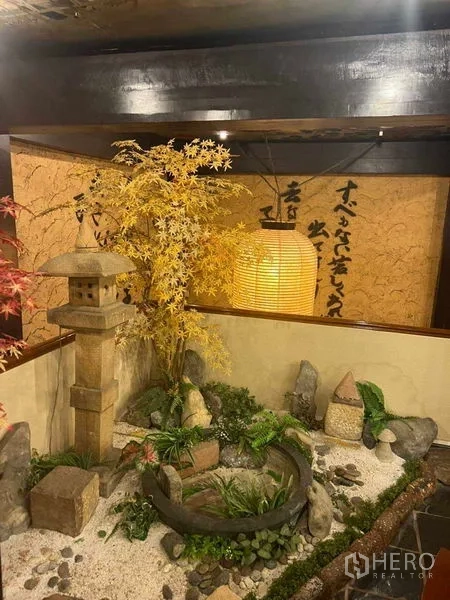 Shophouse for rent in Khlong Toei, Bangkok - Indoor Japanese rock garden with stone lantern, pebbles, and greenery.