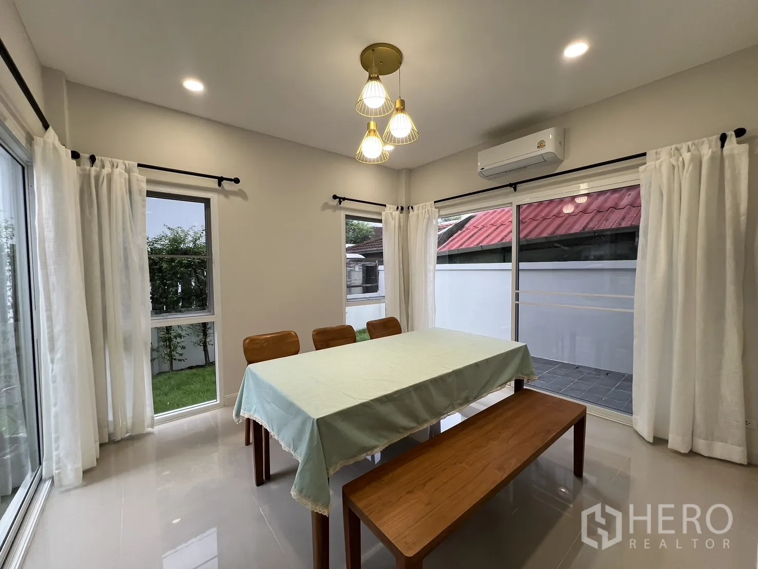 Detached House for rent in Saphan Sung, Bangkok - Corner dining room with pendant lights, windows and table for six.