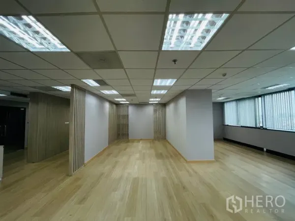 Office Space for rent - Long office zone with LED panel lighting, wood floors, and slatted feature partitions by the windows.