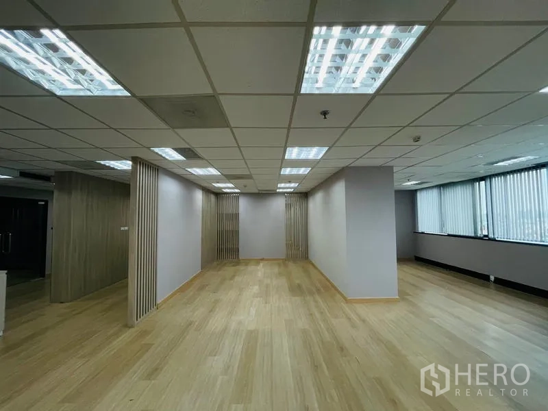 Office Space for rent - Long office zone with LED panel lighting, wood floors, and slatted feature partitions by the windows.