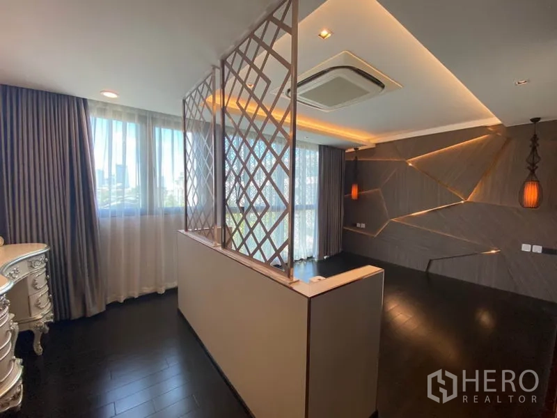 Townhouse for sale in Yan Nawa, Bangkok - Master bedroom with feature wall, warm lighting, lattice divider and dark timber flooring.