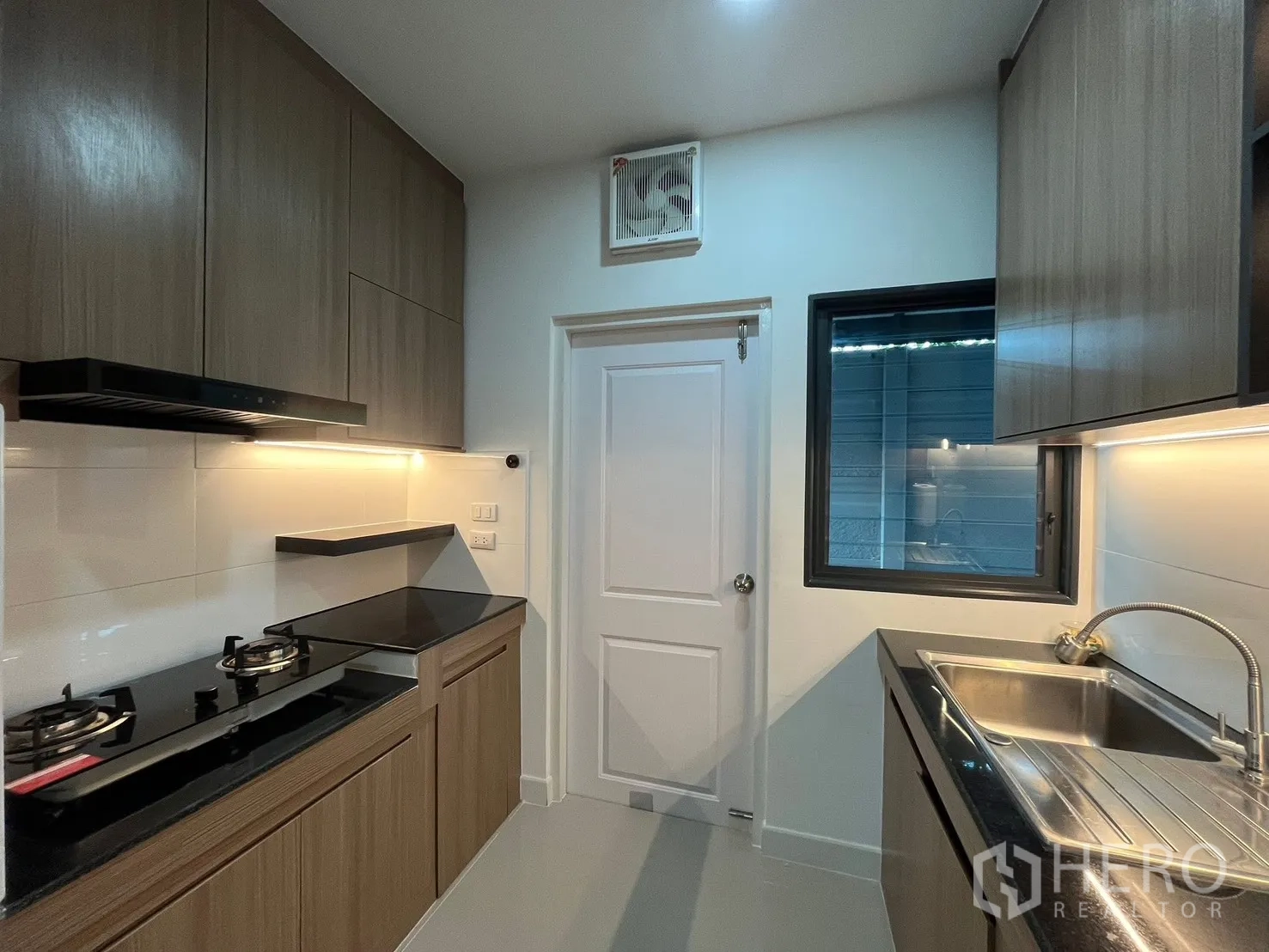 Detached House for rent in Bang Phli, Samut Prakan - Fitted kitchen with gas hobs, black granite counters, and wood cabinetry.