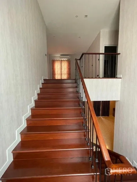 独立式住宅 出售在Mueang Samut Prakan, Samut Prakan - 木楼梯配铁艺栏杆，通往二层平台