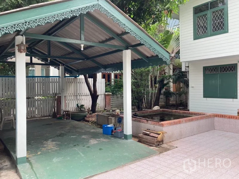 独立式住宅 出租在Sathon, Bangkok - 带雕花装饰的遮棚车位，旁有小水池与绿植的沙吞独栋庭院。