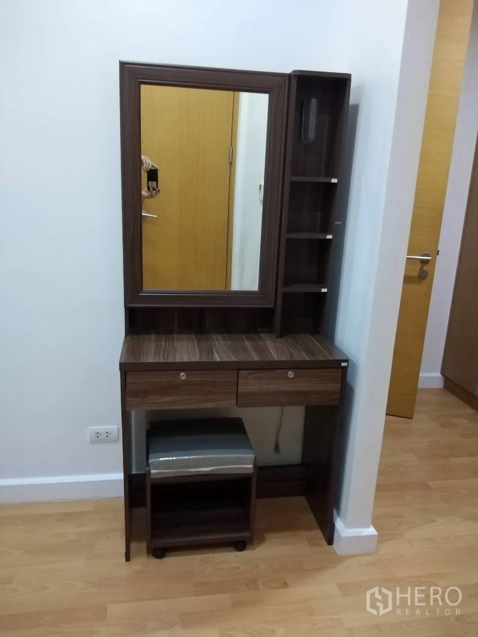 Condominium for rent in Khlong Toei, Bangkok - Bedroom corner featuring a wooden vanity with mirror, shelves, and a stool.