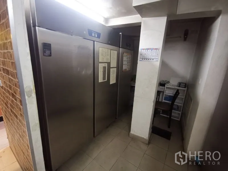 Shophouse for rent in Bangkok - Large commercial refrigerators beside a compact office nook.