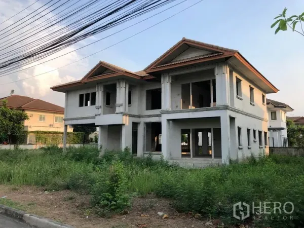 Detached House for sale in Lam Luk Ka, Pathum Thani - Angled exterior of the same two-storey house showing open ground floor space and a wide side yard.