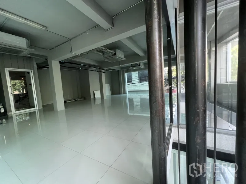 零售空间 出租在Bang Rak, Bangkok - 透过玻璃隔断看到的明亮商铺，开放布局与瓷砖地面。
