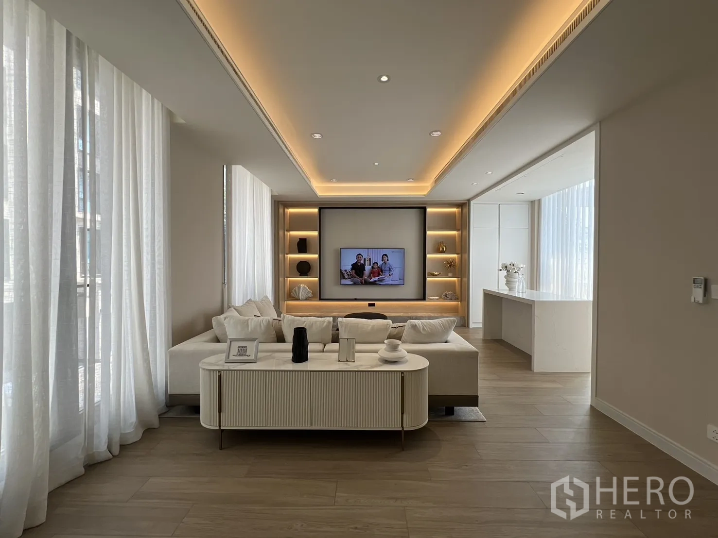 Semi-detached House for sale in Yan Nawa, Bangkok - Large living room with built-in TV wall, shelving, and L-shaped sofa.