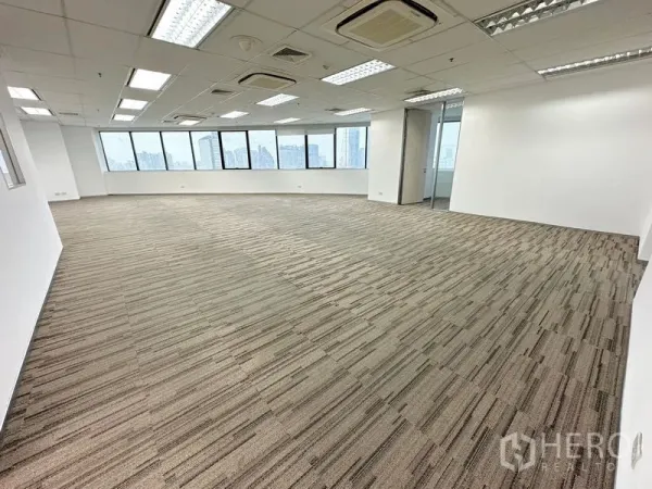办公空间 出租在Watthana, Bangkok - 明亮的开放式办公室，地毯地面、吊顶灯具，整面窗户可观赏曼谷天际线。