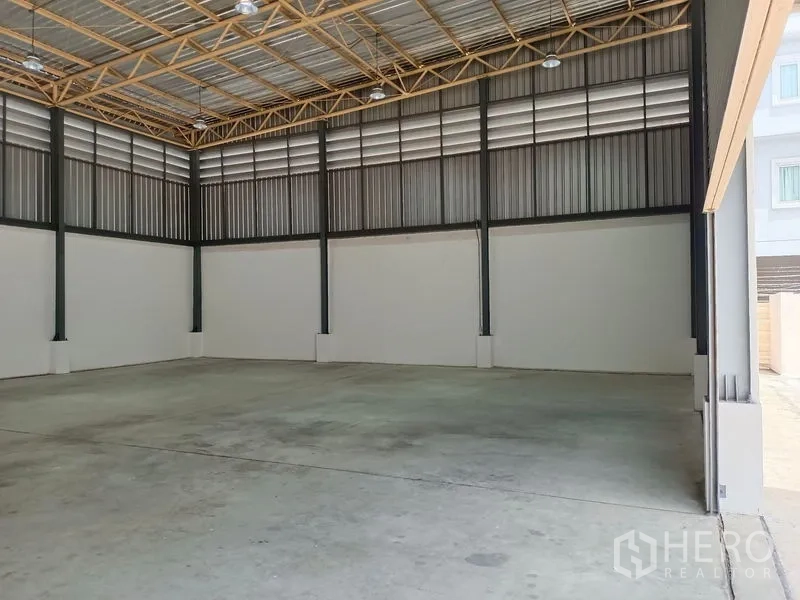 Warehouse for rent in Suan Luang, Bangkok - High‑ceiling warehouse viewed from the entrance with ample floor space and roof vents.