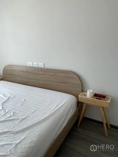 Condominium for rent - Close-up of minimalist wood headboard and small bedside table.