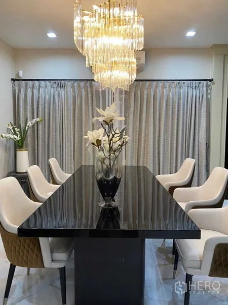 บ้าน ให้เช่าในBang Khen, Bangkok - มุมมองแนวตั้งของโต๊ะอาหาร ใต้โคมระย้าและผ้าม่านยาว