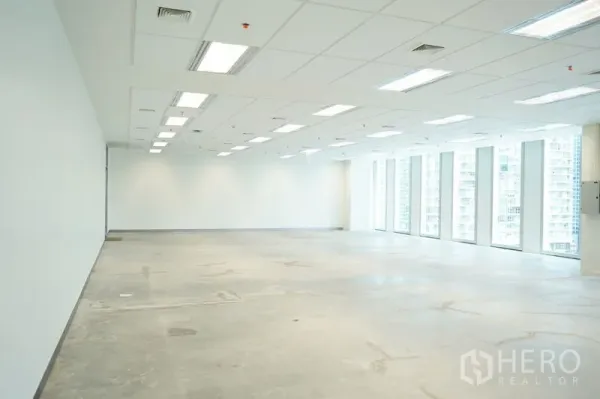 Office Space for rent in Bang Na, Bangkok - Large unfurnished office floor with grid ceiling lights and a wall of tall windows.