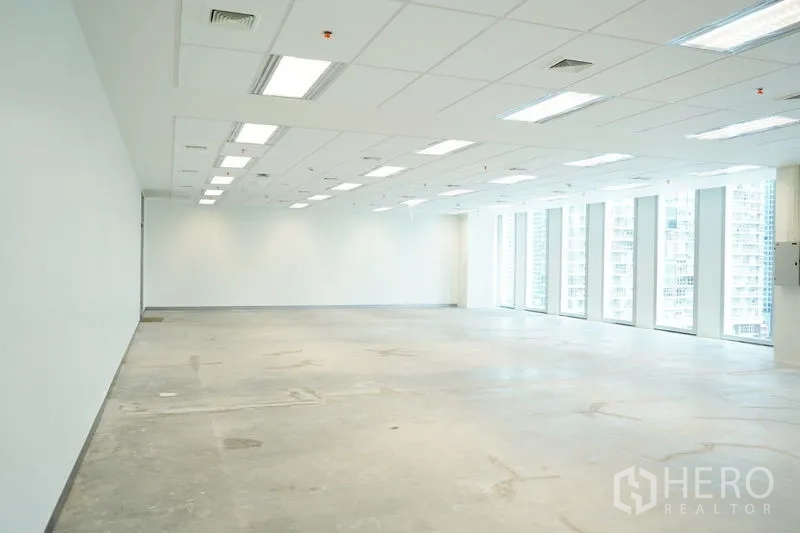 Office Space for rent in Bang Na, Bangkok - Large unfurnished office floor with grid ceiling lights and a wall of tall windows.