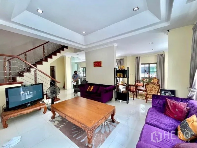 独立式住宅 出租在Prawet, Bangkok - 家庭起居区，层顶吊顶设计，紫色沙发与楼梯。