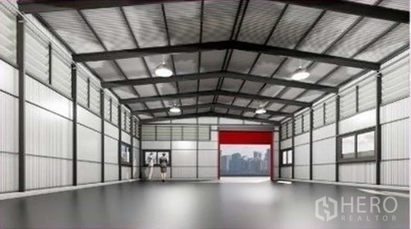 Warehouse for rent in Lat Phrao, Bangkok - Spacious warehouse interior showing a high steel roof, bright lighting, insulated walls and a large roller door.