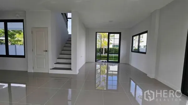 บ้าน ขายในSamut Prakan - ห้องนั่งเล่นและรับประทานอาหารกว้าง ประตูกระจกสไลด์ออกสู่สวนและบันไดกลางบ้าน