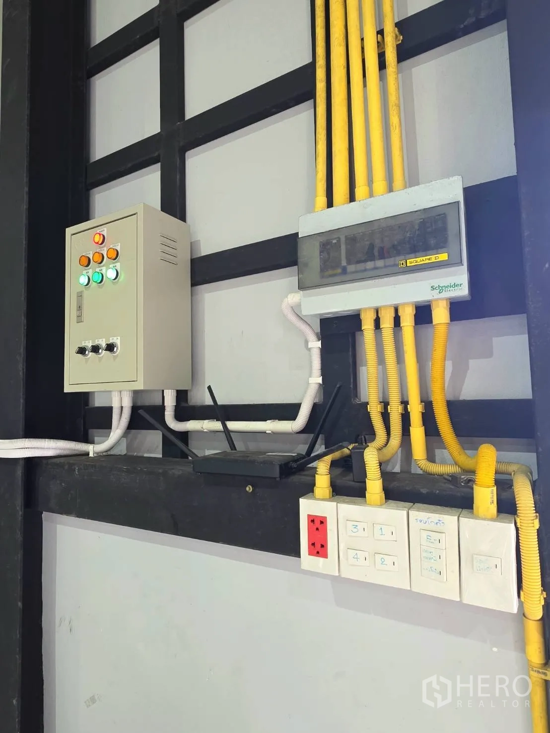 Warehouse for rent in Khlong Toei, Bangkok - Electrical control panels, conduits and power outlets neatly installed on the warehouse wall.