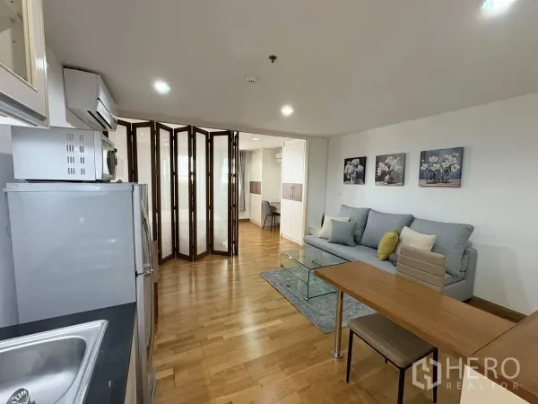Condominium for rent in Khlong Toei, Bangkok - View from kitchenette to living area with folding glass partitions to the bedroom.