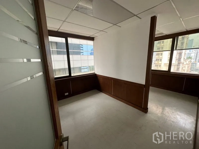 办公空间 出租在Watthana, Bangkok - 小型独立办公室，带窗与木质护墙，可见周边楼宇。