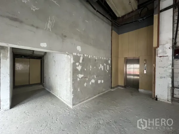 Retail Space for rent - Lift lobby and back‑of‑house wall inside the unfinished retail unit ready for fit‑out.