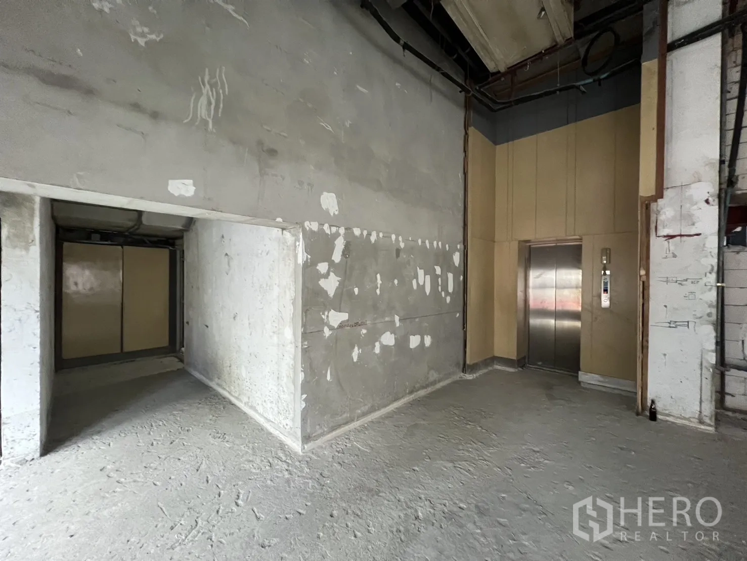 Retail Space for rent - Lift lobby and back‑of‑house wall inside the unfinished retail unit ready for fit‑out.