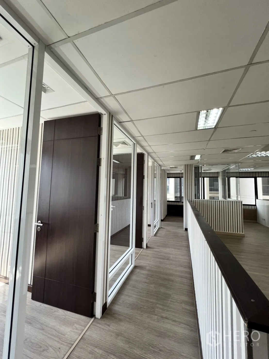 Office Space for rent in Watthana, Bangkok - Hallway of glass-front private offices with wooden doors.