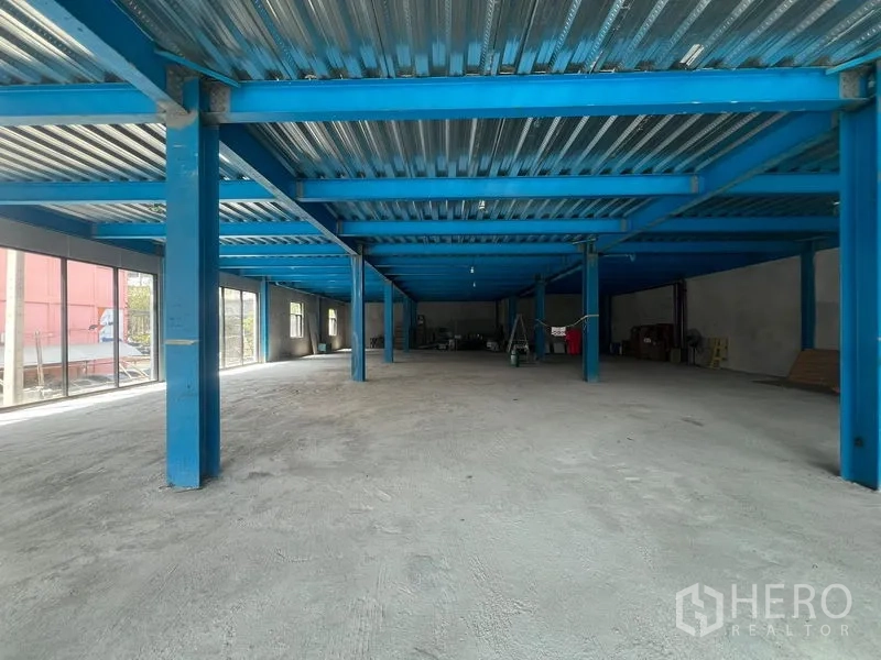 Retail Space for rent in Huai Khwang, Bangkok - Spacious open-plan retail floor with blue steel beams, concrete slab and floor-to-ceiling windows, ready for fit-out.