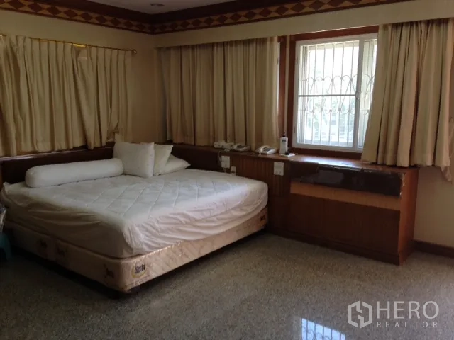 独立式住宅 出租在Bang Rak, Bangkok - 第二卧室，宽大床、内置书桌与米色窗帘。