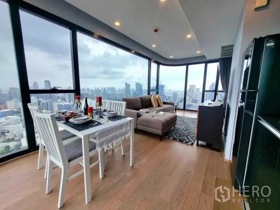 公寓 出租在Bang Rak, Bangkok - 开放式客餐空间，落地窗与木地板呈现城市全景。