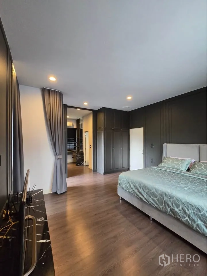 Detached House for rent in Bang Kapi, Bangkok - Spacious master bedroom with bed, wardrobes, and dressing area.