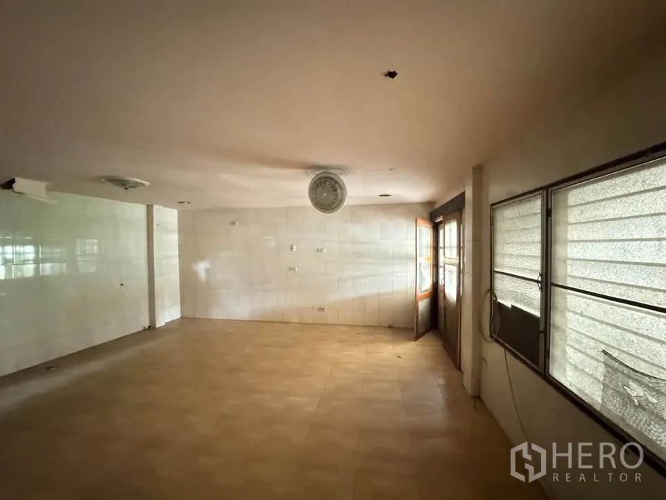 Detached House for rent or sale in Watthana, Bangkok - Tiled kitchen area from another angle showing multiple windows and side exit.
