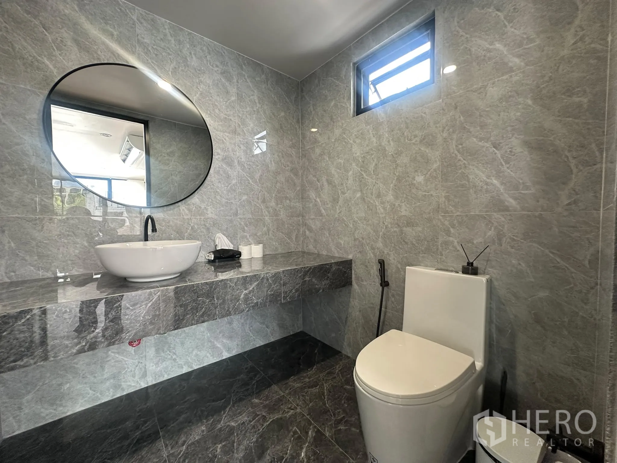 พื้นที่ขายของ for rent in Watthana, Bangkok - ห้องน้ำสไตล์โมเดิร์นกรุหินอ่อนสีเทา กระจกกลม อ่างล้างหน้าแบบวางบนเคาน์เตอร์ และโถสุขภัณฑ์