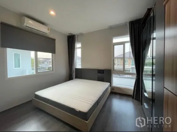 Detached House for rent in Lat Krabang, Bangkok - Bright bedroom with queen bed, dark wood floor, large windows and blackout curtains