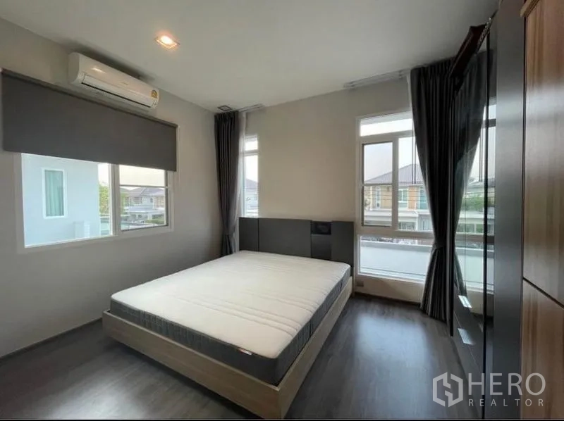 Detached House for rent in Lat Krabang, Bangkok - Bright bedroom with queen bed, dark wood floor, large windows and blackout curtains