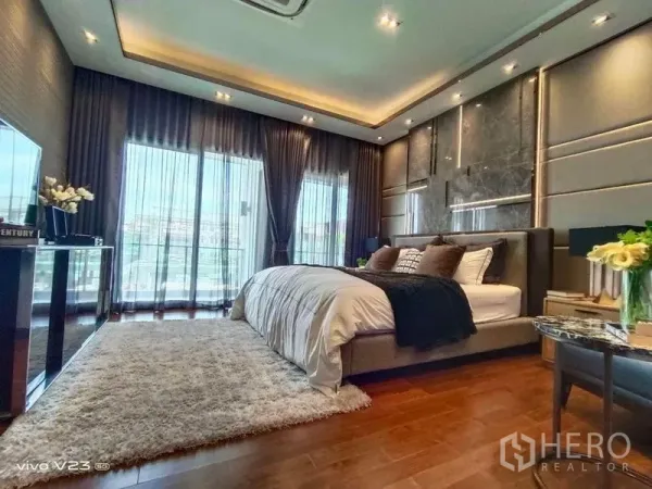 独立式住宅 出售在Wang Thonglang, Bangkok - 主卧奢华设计，带阳台落地窗与木地板，采光充足。