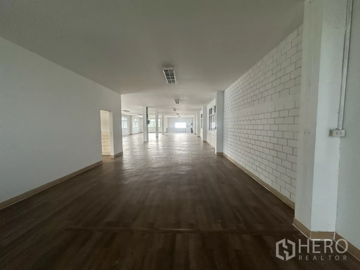 Warehouse for rent in Phra Khanong, Bangkok - Large office floor with wood-look flooring, long corridor and windows.