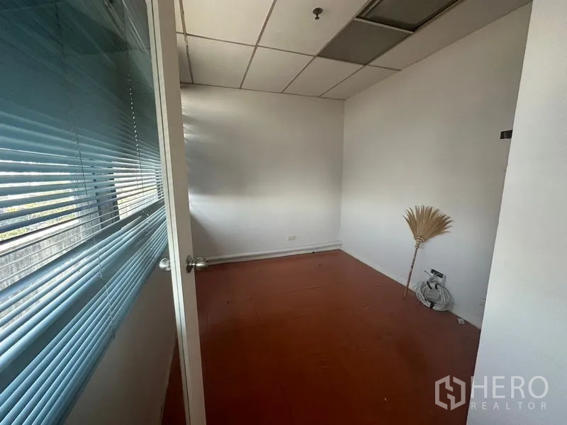办公空间 出租在Yan Nawa, Bangkok - 临窗小办公室，蓝色百叶、吊顶与棕色地砖。