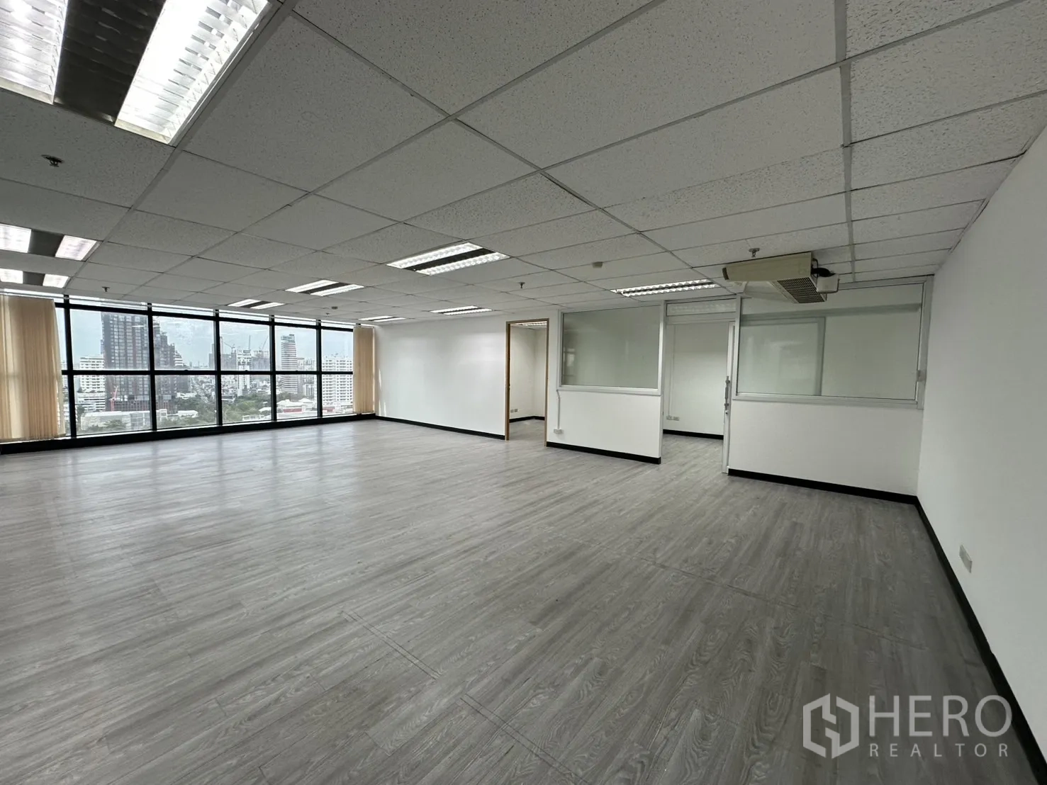 办公空间 出租在Watthana, Bangkok - 宽敞办公大厅，配多间玻璃隔间、百叶与整墙落地窗。