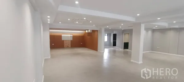 办公室 for rent in Watthana, Bangkok - 长向开放式走廊空间，顶置筒灯与木质端墙。