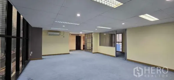 Office Space for rent - Spacious office floor with large windows, AC units and glass-partitioned rooms.