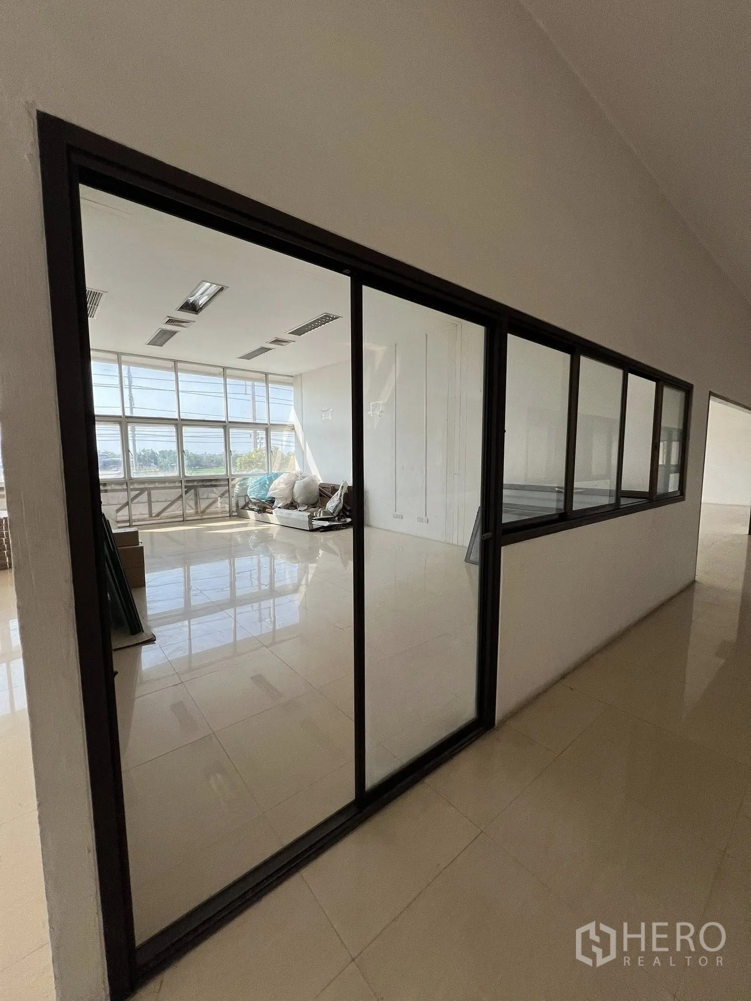 工厂 出租或出售在Sai Noi, Nonthaburi - 玻璃隔断的办公走廊，可俯视厂区