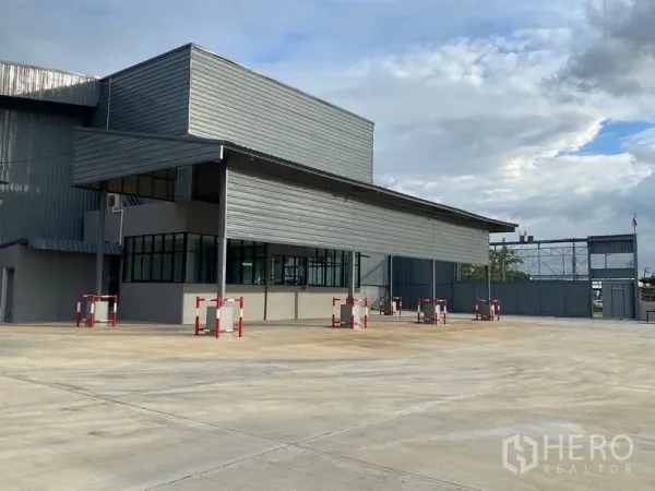 Warehouse for rent in Bang Phli, Samut Prakan - Modern warehouse exterior in Bang Phli with covered loading bay, glass-front office, wide concrete yard and roller shutter door.